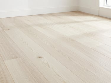 Looking down at precision-milled white oak hardwood flooring, straight clean joints, natural grain pattern, bright daylight, sharp focus.