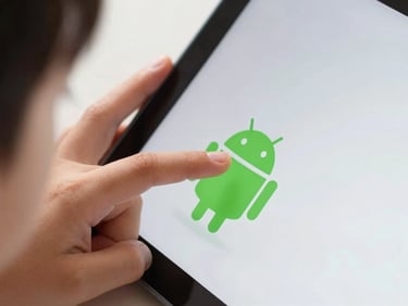 Macro close-up of a child's small hand holding an Android tablet, tapping a large, high-contrast green button with a soft shadow, bright studio lighting.