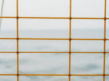 Macro photograph of golden-brown Kevlar sail grid pattern, technical weave, soft natural light