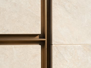 Close-up geometric architectural detail of custom millwork meeting a bookmatched marble wall perfectly, warm natural lighting, minimal aesthetic.