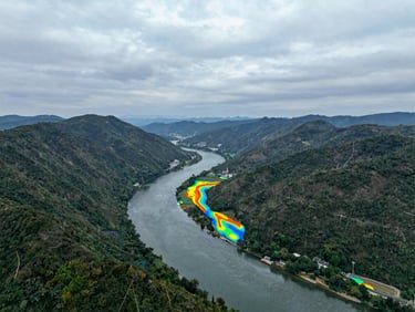 Cool overcast aerial view of a river valley with digital hydrological overlay lines showing flood risk zones, 35mm lens