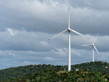 Crisp scientific photography of wind turbines on a coastal ridge under heavy grey clouds, sharp focus, 35mm lens