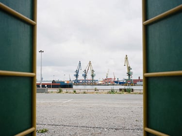 Empty industrial site near a shipping canal, overcast European daylight, clean gravel ground, distant port cranes, 35mm lens
