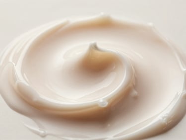 Macro shot of premium cosmetic cream texture, elegant swirl, soft champagne lighting, high-detail clinical focus.