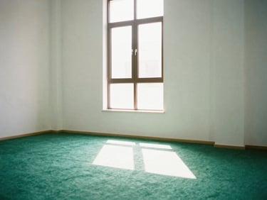A serene view of a modern minimalist prayer room, warm morning sunbeams piercing through the window, 35mm