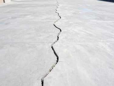 Before and after shot of cracked concrete being restored, showing a smooth, prepped surface, bright daylight, clear transformation.
