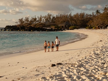Pristine white sand beach in the Galapagos with a family walking near the turquoise water, warm golden hour, 35mm