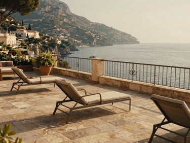 A sun-drenched terrace overlooking the Amalfi coast, warm stone tiles, elegant lounge chairs, soft afternoon light, cinematic 35mm lens
