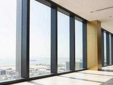 Modern office interior in Abu Dhabi with floor-to-ceiling windows, bright daylight