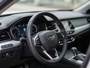 Extremely clean modern car dashboard interior, steering wheel stitching in sharp focus, dust-free digital displays, soft side lighting