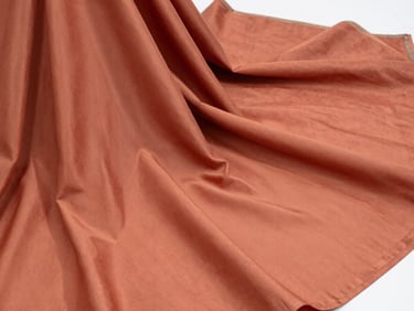 Close-up of elegant draped terracotta-colored Bhagalpuri silk fabric, soft natural highlights, professional B2B product showcase.