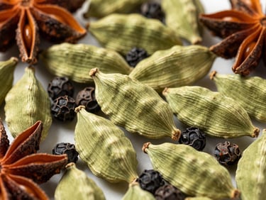 Overhead macro shot of whole green cardamom pods, black peppercorns, and star anise, rich agricultural tones, high-contrast daylight