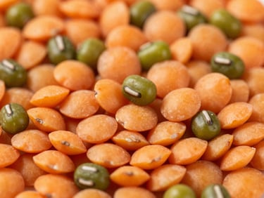 Macro close-up of vibrant orange lentils and polished green mung beans, high-contrast bright daylight, sharp texture detail