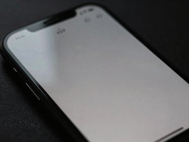 Moody close-up macro shot of a mobile screen showing a minimalist layout, soft natural light reflecting off glass, deep charcoal tones, 35mm.