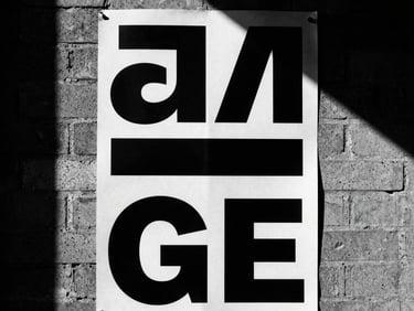 Close-up of a bold monochrome poster pasted on a rough brick wall, harsh sunlight, deep shadows.