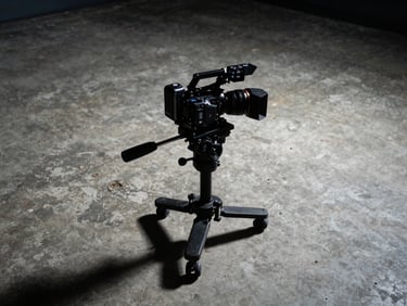 Low-angle dynamic shot of a camera rig on a concrete floor filming streetwear apparel, high-contrast studio lighting, moody shadows, sharp 35mm lens