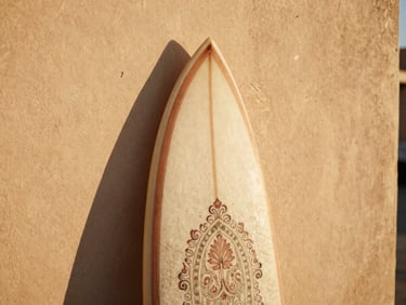 Close-up of a beautifully crafted Dynasty surfboard leaning against a textured warm beige plaster wall, warm Moroccan sunlight casting soft shadows, shallow depth of field, 35mm film