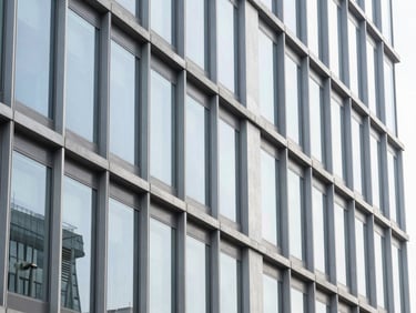 crisp corporate photography, abstract architectural details of a modern steel and glass building, bright natural lighting, ample negative space, high resolution, 35mm