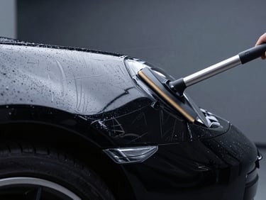 Macro shot of a squeegee smoothing a glossy clear paint protection film over the complex curved fender of a black Porsche 911, cool studio LED lighting, deep shadows, sharp macro details, 50mm