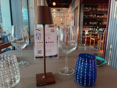 Sala del Bistrot Pedol Porta Nuova con tavoli affacciati sulle vetrate e cantina sullo sfondo