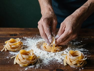 Macro shot of hands dusting flour over fresh golden pasta on a dark wooden table, soft side light, 35mm film grain.
