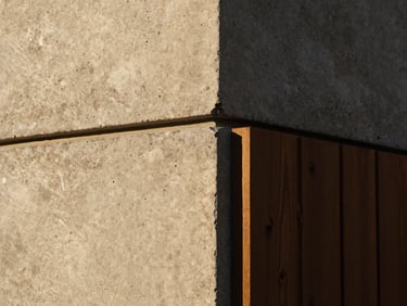 Close-up of tactile architectural detail, a perfect joint where raw concrete meets dark timber, dramatic side light, sharp focus, 35mm