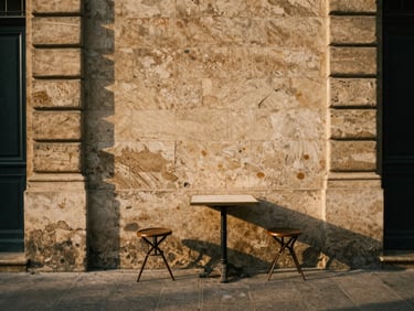 A quiet courtyard in Paris with weathered stone walls, a single bistro table, soft morning shadows, rich textures, warm editorial travel photography.