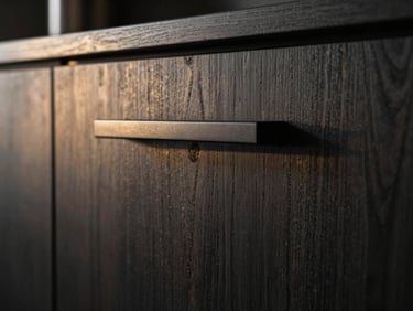 Macro shot of a modern dark wood kitchen cabinet door with a clean minimalist handle, dramatic side lighting