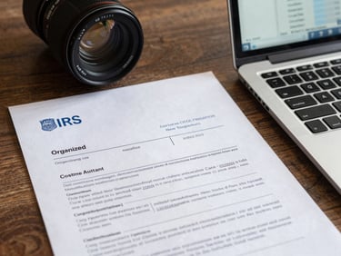 Organized desk with IRS correspondence letters and a laptop showing a resolution case tracker, clean overhead lighting