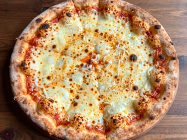 Close-up of a Neapolitan pizza with 'nduja sausage and roasted red peppers, vibrant orange and red tones, intense firelight glow.