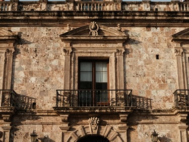 Tight detailed crop of classic colonial stone facade in Oaxaca Centro, warm natural light.