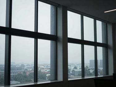 Wide shot of a modern, structured office environment with large windows and diffused daylight, geometric shadows on the wall.