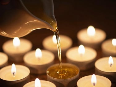 Close-up of golden herbal oil pouring slowly from a ceramic vessel, warm candlelight, soft focus, 35mm