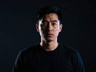 High-contrast studio portrait of a male creative director, dramatic backlighting, moody dark tones, 35mm photography