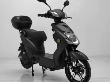 Sleek matte black electric scooter with a storage trunk parked on a white floor.