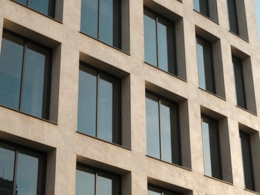 Architectural detail of a modern African business hub, soft natural window light, muted ivory and deep blue tones, architectural depth, 35mm