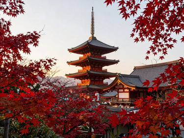 Stunning golden-hour view of a traditional wooden pagoda in Kyoto surrounded by vibrant red maple leaves, soft sunlight