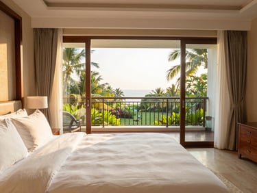 Sunlit interior of a spacious premium hotel suite, plush white bedding, private balcony overlooking tropical gardens, warm morning light, architectural framing, 35mm lens
