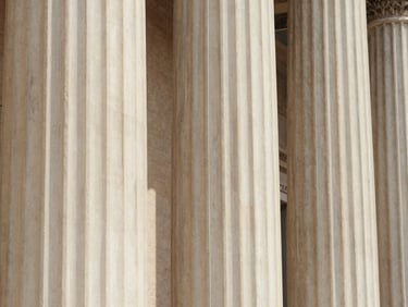 Sunlight hitting a marble column in Rome, clean architectural lines, warm European tones
