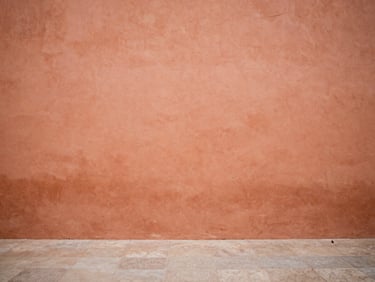 Warm terracotta walls of an old Spanish plaza, soft natural light, minimalist composition