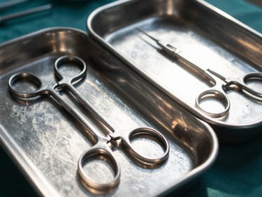 Detailed close-up of packaged surgical instruments in sterile steel trays, hard dramatic daylight, high-contrast metallic accents