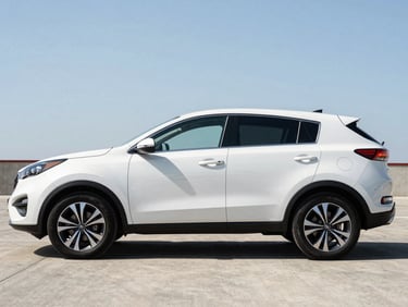 Three-quarter exterior of a white Kia Sportage SUV parked on a Cayman concrete lot under midday sun, full profile view, tyres and body panels clearly visible