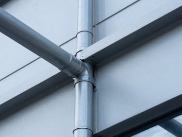 Close-up of a fire stop system installation in a commercial building, showing precise sealing around pipes, crisp daylight, cool blue and steel gray tones, high-contrast architectural photography.
