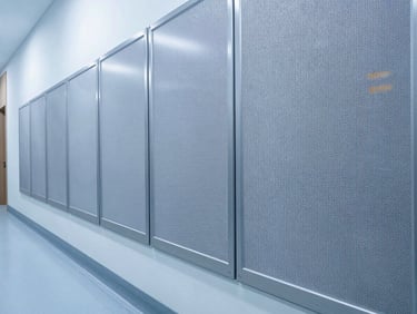 Clean close-up of a hygienic wall protection system installed in a modern hospital corridor, cool-toned architectural lighting, high-contrast, no people.