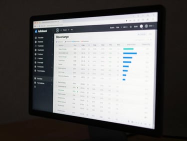 Web application dashboard displayed on a desktop screen, data table and chart widgets visible, dark sidebar, studio lighting, sharp display clarity