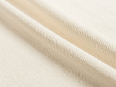 Close-up of elegant cream-colored fine-gauge knit fabric draping softly, natural warm lighting, showing detailed weave structure, 35mm