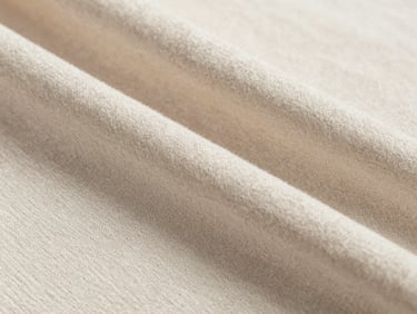 Macro shot of premium cotton single-jersey weave, neutral cotton tones, bright clean daylight, extreme close-up of textile structure.