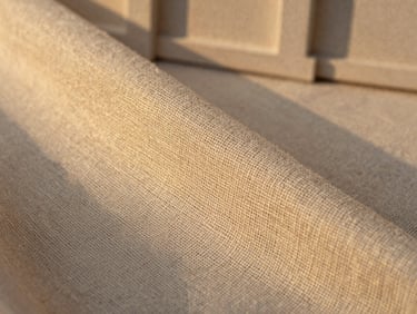 Macro shot of woven linen fabric texture, soft golden-hour sunlight, showing natural fibers and breathable weave, 35mm
