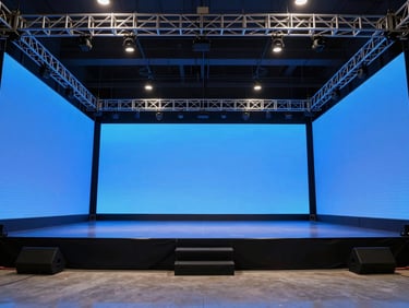 Ultra-wide shot of a massive empty corporate stage with glowing blue LED walls and perfectly aligned metal trusses, dramatic architectural lighting, no people, pristine setup.