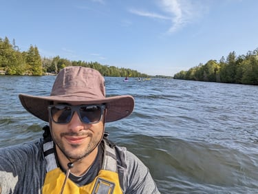 a man in a hat and sunglasses on a boat